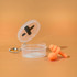 An orange silicone earplug set in a clear case with a keychain attachment. The case lid is open.