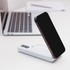 A white power bank with a wireless charging feature and a smartphone in the process of being charged.