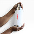 A drink bottle in silver and white, featuring a logo, held between two hands.