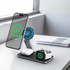 A magnetic, 3-in-1 wireless charging station in black, featuring a phone, AirPods, and an Apple Watch on display.