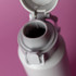 A drink bottle in grey with a cap and a spout, featuring a logo on the side.