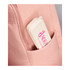A pink backpack with a cream-coloured bamboo fibre cutlery set case peeking out from a side pocket.