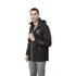 A man wearing a black rain jacket with a logo, featuring a hood and zip pockets.
