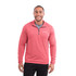 A man wearing a red quarter zip jumper with a logo on the chest, featuring a textured fabric design.
