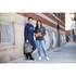 A man in a navy hoodie and a woman in a grey hoodie pose casually on a street corner, both with backpacks.