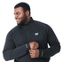 A man wearing a black quarter zip jacket with a logo on the chest, featuring long sleeves and a comfortable fit.