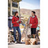 A red puffer jacket with a hood, worn by a man and a woman outdoors, with a logo visible on the jacket.