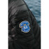 A black puffer jacket featuring a logo on the sleeve, showcasing its light down design.