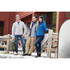A group of three people wearing jackets, including a blue insulated one, in a rustic outdoor setting.