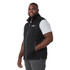 A black eco waterproof softshell vest with a zip front, featuring a logo, worn by a smiling man.