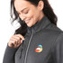 A grey women's softshell jacket with a zippered pocket, featuring a colourful logo on the chest.