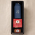 A blue drink bottle, a Christmas pudding, and a jar of sauce in a black box hamper.