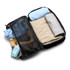 A packing cube in black, filled with rolled clothing items and a bottle of wash liquid. It has a mesh section and a logo.