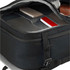 An open black travel backpack displaying multiple compartments containing notebooks and a small device.