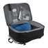 A black travel backpack with grey lining, featuring compartments for a blue pillow and various travel essentials.