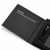 A black wireless power bank with a USB cable, displayed in a sleek box, featuring branding.
