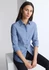 A women's long sleeve shirt in blue and white stripes, featuring a collar and rolled sleeves. It has a brand logo.