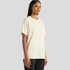 A cream-coloured t-shirt in a relaxed fit, displayed on a model against a grey background. Includes a logo.
