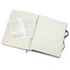 An extra large Moleskine soft cover notebook in black, open to reveal blank pages and a branded insert.