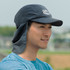 A navy Legionnaire hat with a brim and neck flap, worn by a smiling man outdoors.