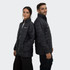 A black puffer jacket featuring a logo, worn by two people standing back to back.