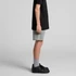 Youth stadium shorts in grey, featuring a logo, paired with a black t-shirt and black sneakers.