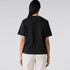 A back view of a black tee shirt, featuring short sleeves and a relaxed fit. The fabric appears smooth and casual.