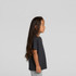 A black kids' heavy faded tee displayed on a child with long hair, set against a plain background.