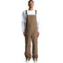 Canvas overalls in brown, featuring adjustable straps and a relaxed fit. Model is wearing them with a white long-sleeve shirt.