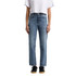 Straight jeans in light blue denim, featuring a high-waisted design. Paired with a white cropped top and black sneakers.
