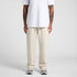 Cuffless track pants in a light cream colour, paired with a white t-shirt. A logo is visible on the garment.