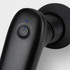 A compact handheld massager in black with a power button and a blue indicator light.