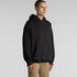A black hoodie with a front pouch pocket and an attached hood, featuring a brand logo on the side.