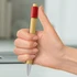 A bamboo pen held in a hand, featuring a red accent on the grip and a silver tip.
