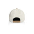 A two-tone camo cap featuring a cream-coloured exterior and a contrasting brown adjustable strap at the back.