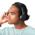A pair of black Skullcandy Icon 180 wireless headphones worn by a person with curly hair.