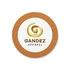 A circular cork coaster featuring a white centre with a gold logo and brown text.