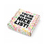 A gift box featuring festive designs in red, green, and gold, with a prominent black text message.