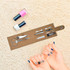 A cork manicure set with scissors, files, and nail polishes in pink and white, displayed on a soft surface.