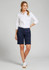 A woman in a white shirt and navy chino shorts stands against a grey background. The shorts feature a logo.