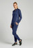 A woman wearing a navy blue unisex mid-layer top with long sleeves and matching pants, standing against a plain background.