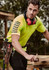 A Hi Vis yellow short sleeve polo shirt worn by a man, featuring a logo and dark accents, designed for workwear.
