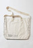 A beige unisex tote bag featuring a patterned edge and a logo. It has two carrying handles and a shoulder strap.