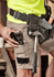 Men's summer cargo shorts in khaki, featuring pockets and a belt, complemented by a tool belt with tools.