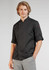 A black long sleeve chef jacket with rolled-up sleeves, modelled by a young man. It features a logo on one sleeve.