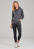 A woman in a grey hoodie poses with black 7/8 length leggings. The outfit includes casual white sneakers.
