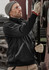 A black water-resistant 1/4 zip pullover worn by a person with safety glasses and gloves, working with machinery.