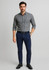 A man stands wearing a checkered grey shirt and navy tapered stretch chino pants, finished with black shoes and a belt.