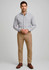 A man stands wearing a checked shirt and light brown modern stretch chino pants, with a logo on the pants.
