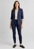 A woman wearing a navy blazer and high-rise navy leggings, styled with a white blouse and loafers.